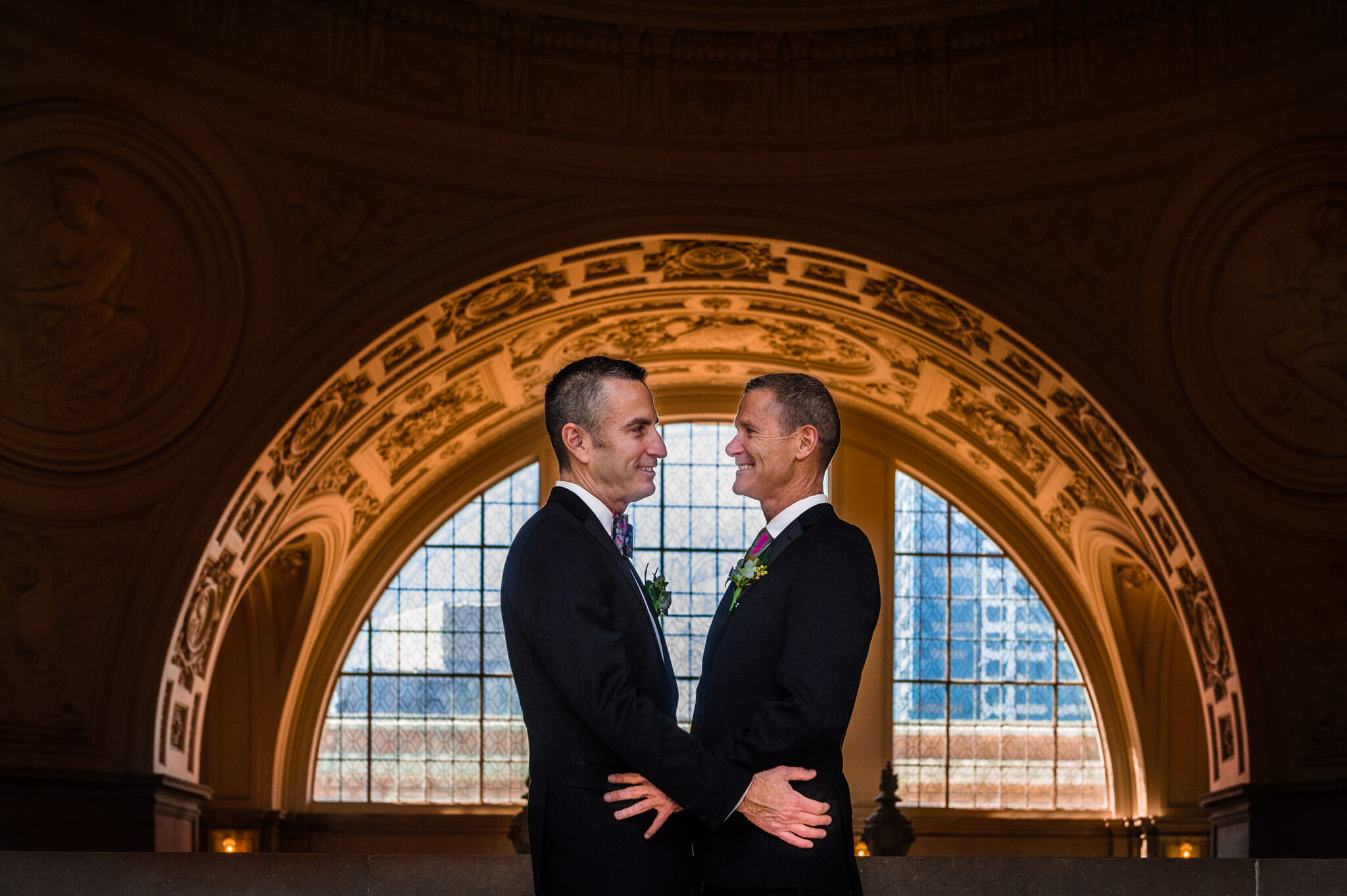 Two newlyweds smile at each other after same-sex marriage at San Francisco City Hall