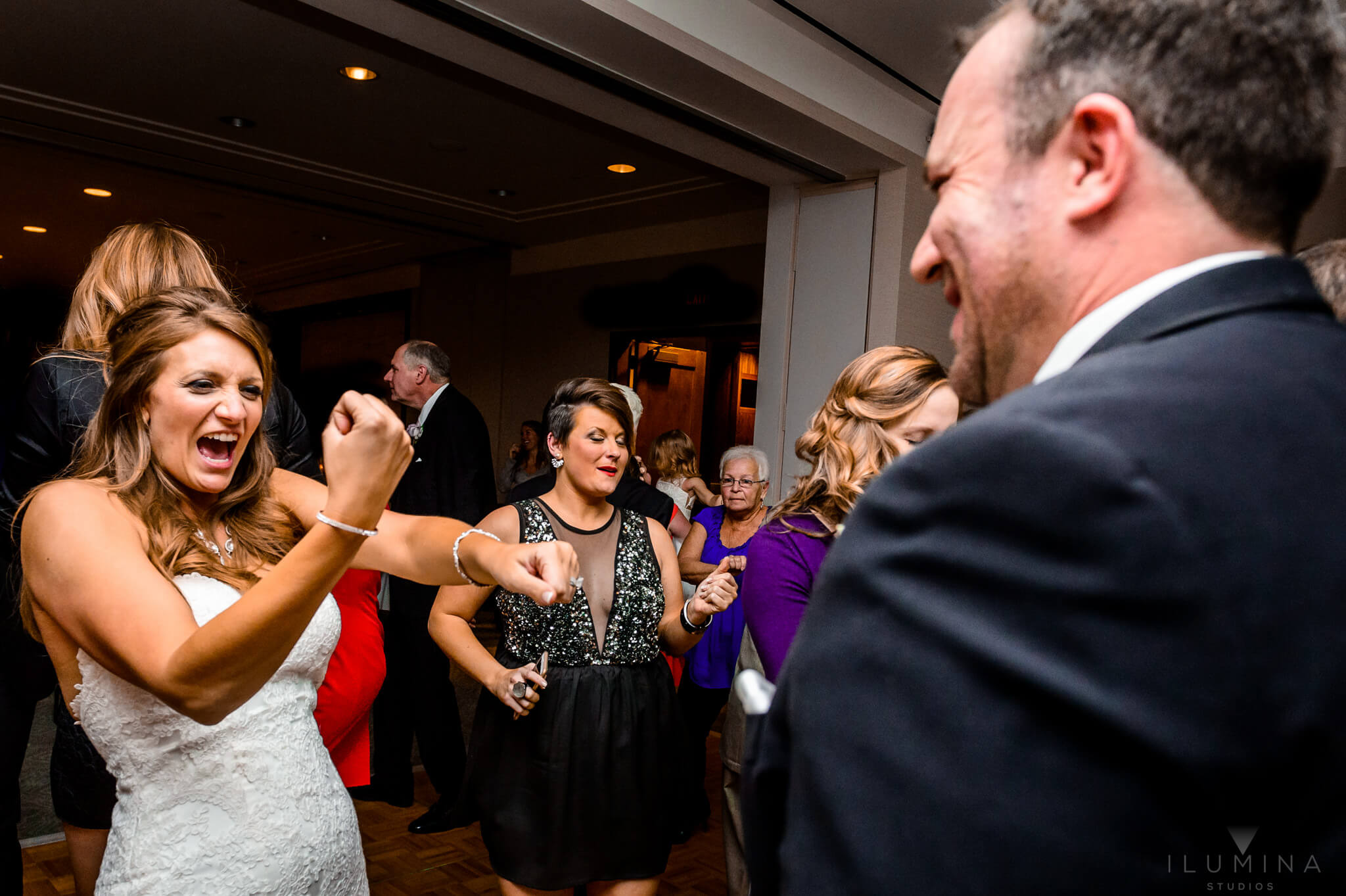 Color photo of bride celebrating with guests at wedding