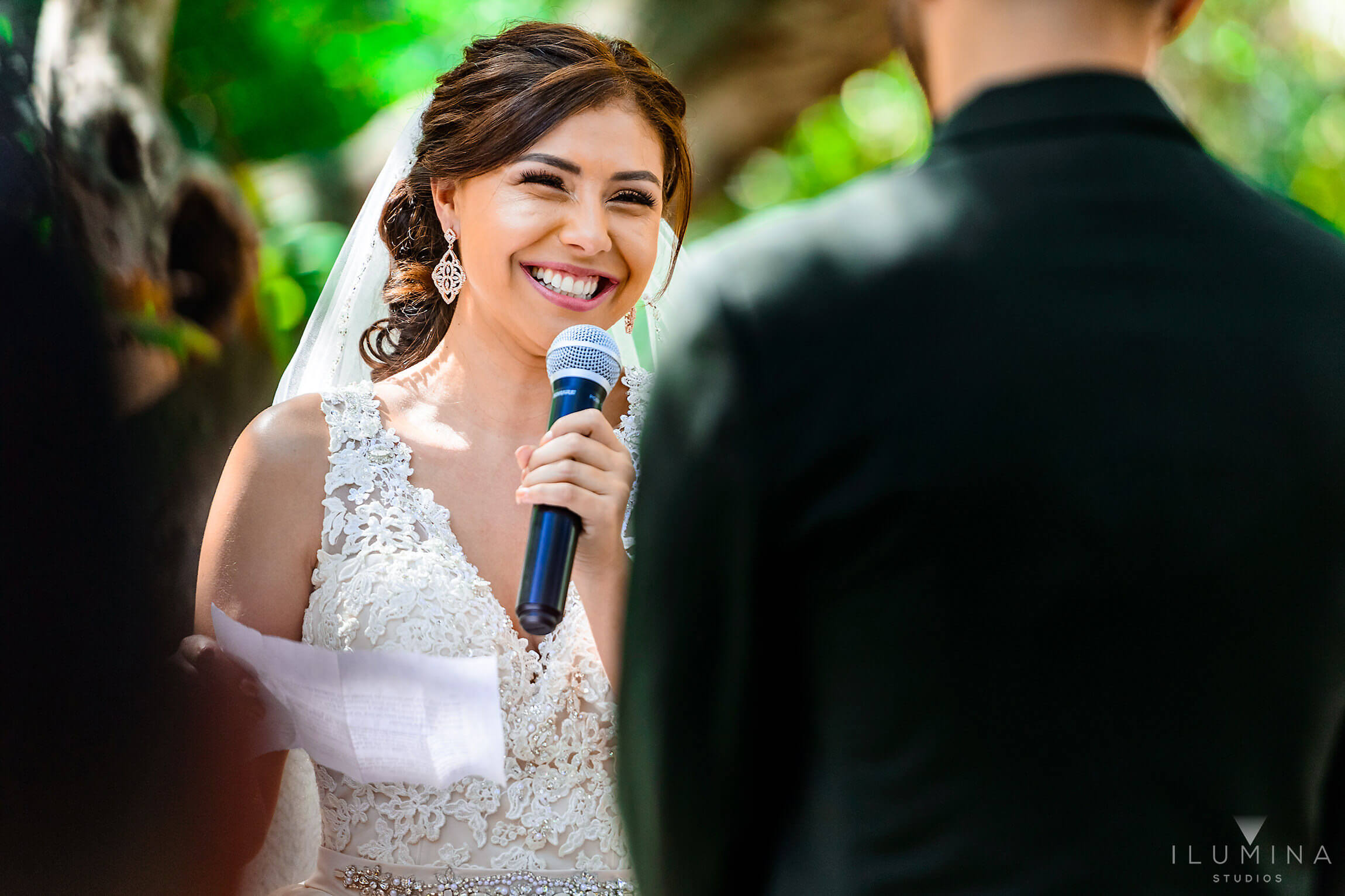 Color photo of bride laughing as she reads vows to groom at the altar at Anaheim Oak Canyon Nature Center wedding