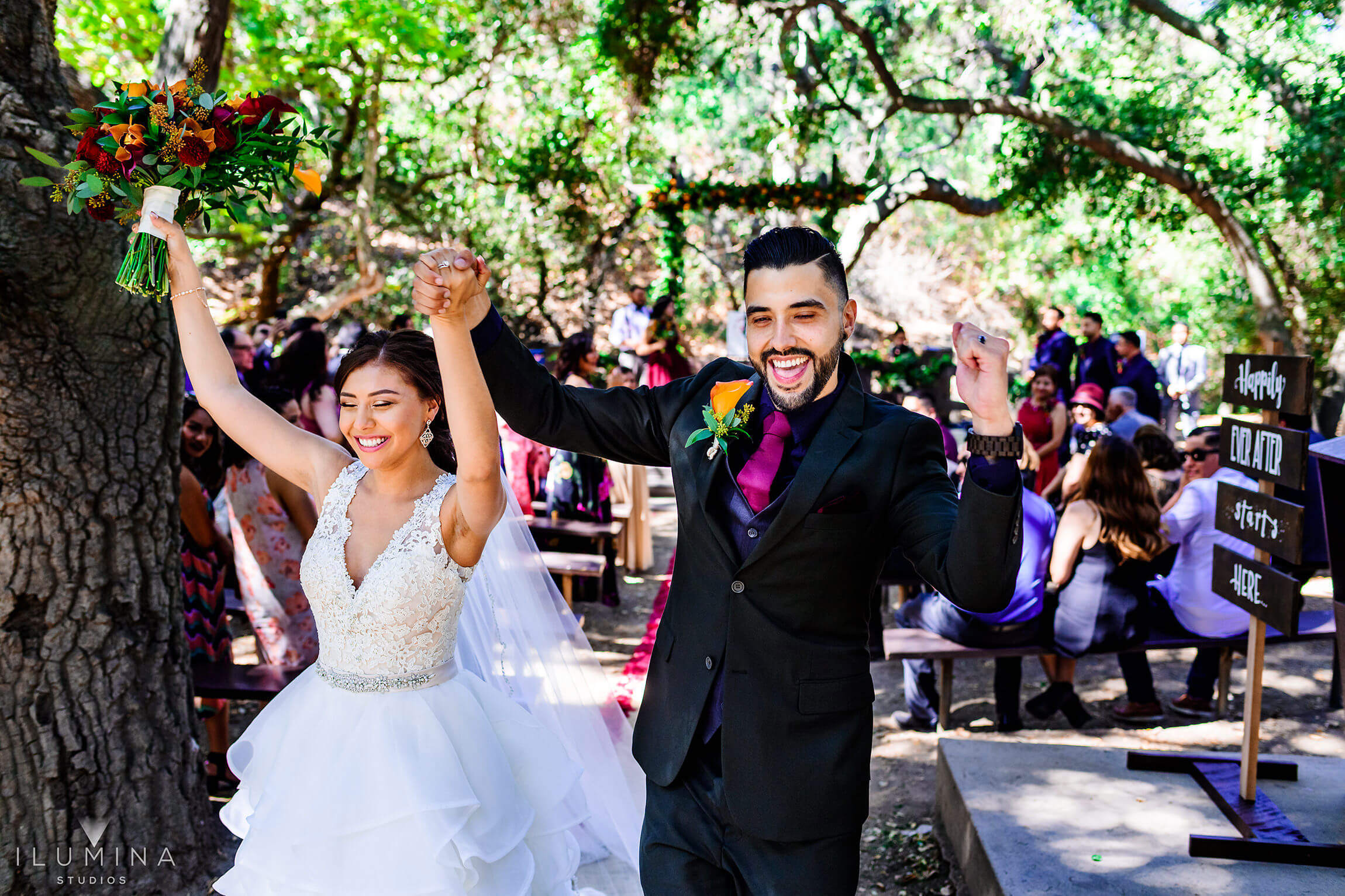 Bride and groom hold hands and celebrate after finishing marriage ceremony at Anaheim Oak Canyon Nature Center wedding