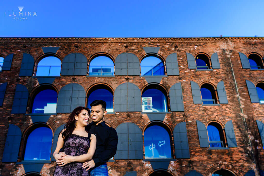 Multiple exposure image of man and woman laughing and embracing in front of brick building in Brooklyn, New York City