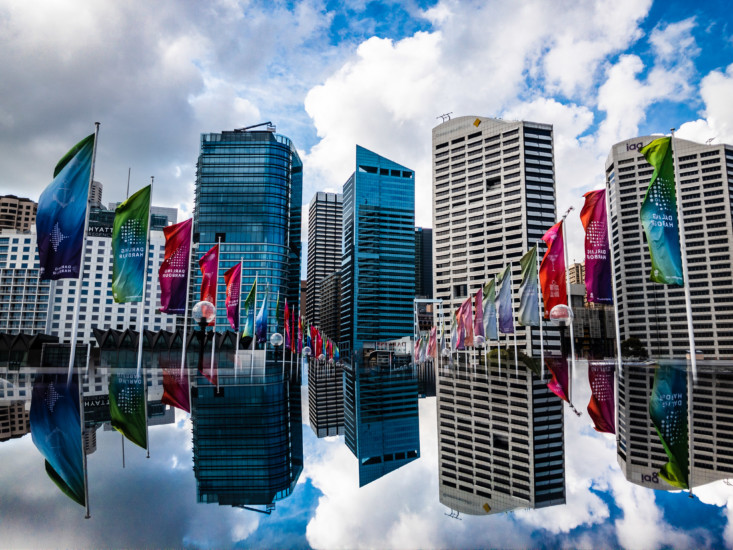 Image of city and flags reflecting on the water