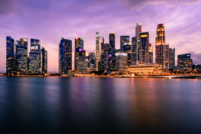 City skyline lit up with lights at sunset near the water