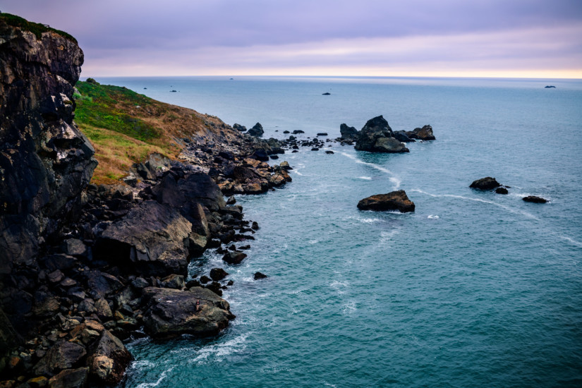 rocky cliffside near a big blue source of water